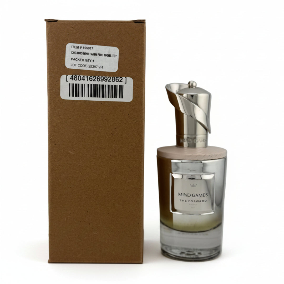 A bottle of Mind Games The Fragrance next to its brown cardboard box, photographed on a light gray background.
