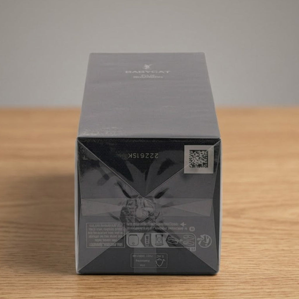 A dark gray rectangular product box with a glossy finish, standing upright on a light wood surface against a neutral gray background.
