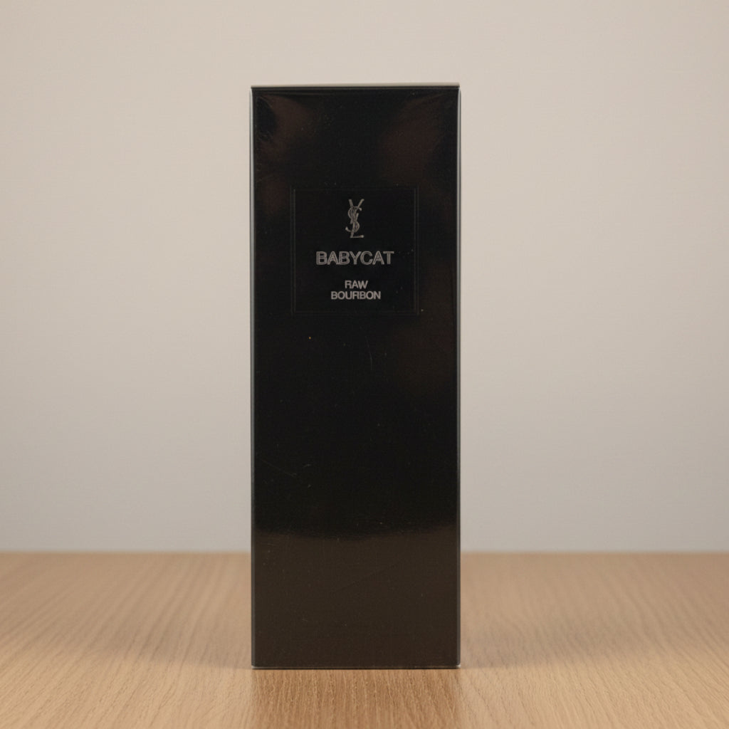 A tall, black rectangular box for Babycat Paw Bourbon perfume, standing upright against a light gray background.