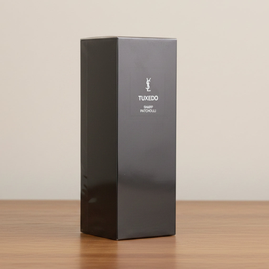 A tall, black rectangular box with a glossy finish, featuring the text 'TUXEDO' and 'DRESS TUXEDO' in white, standing against a neutral light gray background.