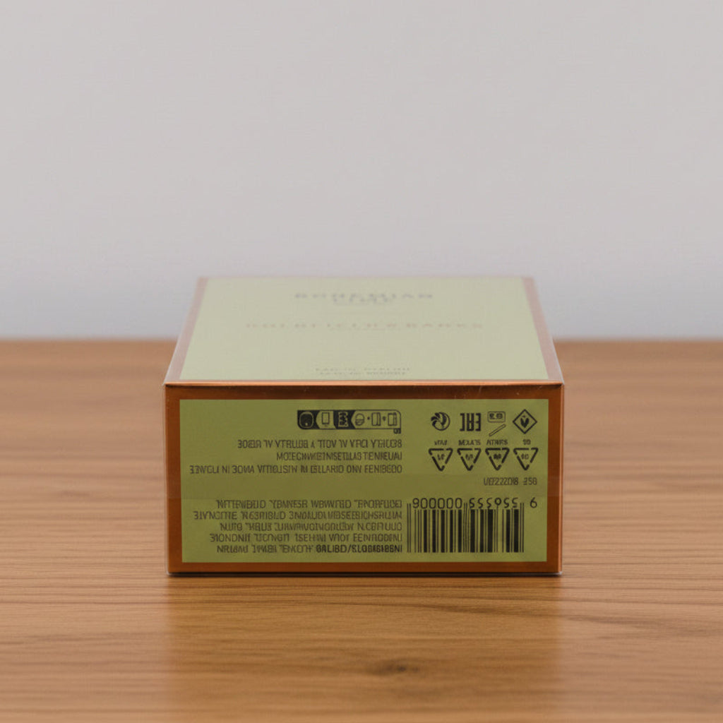 A square product box shown from a side angle on a plain white background, with a pale yellow-green front panel, brown border, and a green back panel featuring a barcode and small printed text.