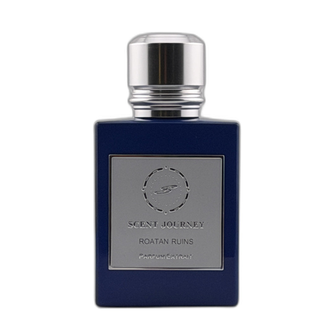A dark blue rectangular perfume bottle with a silver metallic cap and a silver label reading 'SCENT JOURNEY ROATAN RUINS PARFUMERIE'.