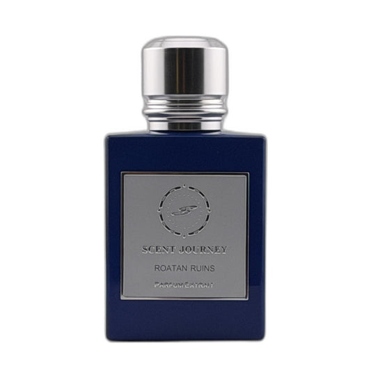 A dark blue rectangular perfume bottle with a silver metallic cap and a silver label reading 'SCENT JOURNEY ROATAN RUINS PARFUMERIE'.